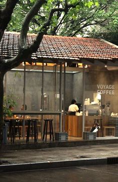 a man sitting at a table in front of a coffee shop