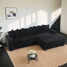 a living room with black furniture and white walls