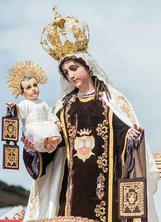 a statue of the virgin mary holding a baby jesus in her arms and wearing a crown