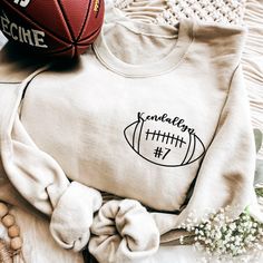 a sweatshirt with an embroidered football on it