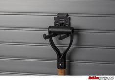 an umbrella hook on the side of a garage door with a gray wall behind it