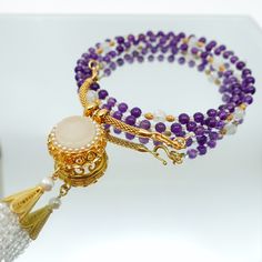 This beautiful necklace set features a multi-style beaded amethyst necklace with a white jade and zircon tassel pendant. The necklace is made up of 81 primary gemstones, with every 9 gemstones grouped and connected by spacer gemstones. The pendant can be detached from the necklace and replaced with any pendant you like, and the necklace can also be worn as a glasses chain. The ancient Chinese believed that the number 9 symbolized eternity, and that surviving 81 tribulations could help a person r