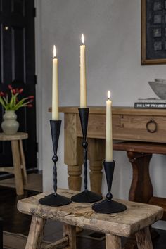 three candles are sitting on a wooden table