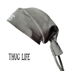 Thug Life Beanie Tie in Dark Gray is 90s-inspired by the iconic style of the legendary 2Pac, by Street Knowledge brand, that effortlessly merges streetwear with a touch of nostalgia and street fashion to your wardrobe. Available in two sizes: S/M and L/XL Made of very soft quality material (95% cotton and 5% polyester) Brand new S/M - width: 26.5 cm, length: 44 cm. L/XL - width: 28.5 cm, length: 46 cm. Material: 95% cotton, 5% polyester Fitted Hats For Streetwear, Unisex Casual Hat For Streetwear, Basic Streetwear Hat, One Size Fits Most, Trendy Gray Hat For Streetwear, Basic Streetwear Hat, Basic Adjustable Hats For Streetwear, Adjustable Basic Hat For Streetwear, Street Knowledge, Hip Hop Hat