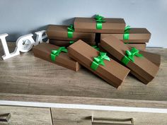 several brown boxes with green bows are stacked on top of each other in front of a clock