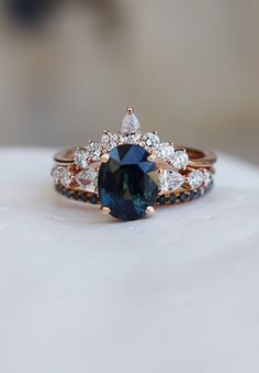 a blue and white diamond ring sitting on top of a table