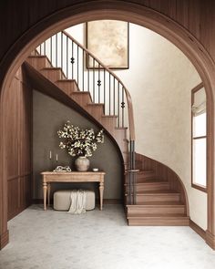 a vase with flowers sitting on top of a wooden table next to a stair case