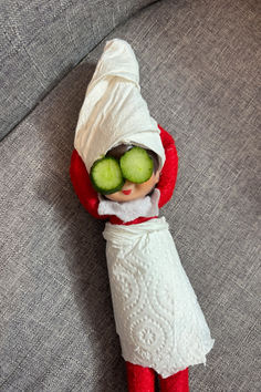 an elf with cucumbers on his face laying on a couch next to a pillow