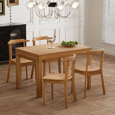 a dining room table with chairs and a bowl of fruit on the table next to it