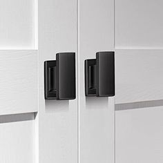 two black handles on white cabinets in a room