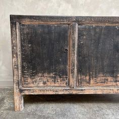 an old wooden cabinet with peeling paint on the doors and bottom part of it's door