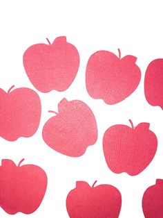 red apples are arranged in the shape of an apple on a white background with pink shadow