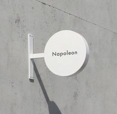 a white sign that says napolen on it's side next to a wall