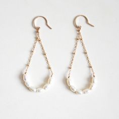 Freshwater pearl arch dangle earrings handmade with hypoallergenic 14k gold-filled wire that is nickel-free. Freshwater pearls are cultivated in freshwater environments like lakes and rivers. Their thick nacre coating makes them durable and relatively sweat-resistant, ideal for daily wear. These elegant earrings are suitable for both everyday and special occasions! Each piece is handcrafted, so slight variations in shape may occur. These earrings will be made for you after the order is placed. MATERIALS14k gold filled wireFreshwater pearlsRubber Ear nuts DIMENSIONSapprox. 7/8" (24mm) width x 2 1/4" (58mm) length 14k Gold Filled Pearl White Dangle Pearl Earrings, White Long Drop Pearl Earrings In 14k Gold Filled, White Long Drop Pearl Earrings In 14k Gold, Minimalist Wire Wrapped Pearl Drop Earrings, 14k Gold-filled Teardrop Pearl Chain Jewelry, White 14k Gold-filled Drop Pearl Earrings, White Teardrop Linear Earrings Dainty Style, Delicate Wire Wrapped Pearl Earrings, Delicate Teardrop Wire Wrapped Pearl Earrings