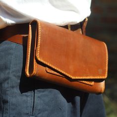 a person is holding a brown leather bag in their hands and there is no image on it