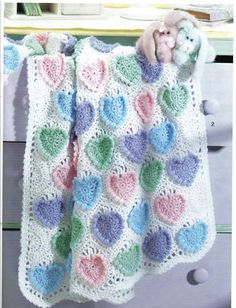 a crocheted blanket with hearts on it