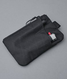 an empty black bag on a gray surface with a red and white tag attached to it