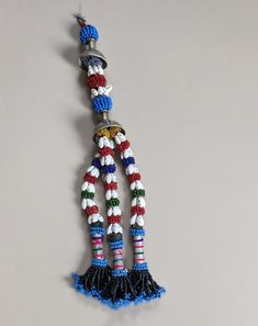 12" long, beaded Baloch (Baluch) tribal tassel with two metal tops and traditional beaded patterns. Lots of unique details, striped patterns, beaded spacers, and shell accents. Traditional Baluch item used both as adornment and as a talisman. You'll receive this exact piece. Different monitors and phone apps show colors differently. I do my best to accurately document color using both photos and written descriptions. If you have any questions, please send me a message. Traditional Handwoven Beads For Festivals, Traditional Handwoven Festival Beads, Traditional Beaded Necklace With Tassels, Bohemian Beads With Tassels For Festival, Traditional Dangling Beads For Festivals, Beaded Patterns, Sewing Embellishments, Phone Apps, Stripes Pattern