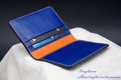 This wallet is unique, you will never see the exact same thing. The exterior alligator leather is cut along its scale's edge to show an orange layer below. The orange line is unique because the texture of the alligator is unique. The wallet opens vibrantly with blue and orange color inside. I've tried my best to put my unique technique and my passion into this small piece. Every single wallet is made to order, there won't be a second same thing. If you are looking for a small accessory but it's Designer Blue Card Holder For Everyday, Luxury Blue Card Holder As Gift, Luxury Blue Card Holder For Gift, Luxury Blue Card Holder Gift, Blue Bifold Card Holder For Formal Occasions, Luxury Blue Leather Card Holder, Blue Business Card Holder With Interior Slots, Business Blue Card Holder With Interior Slots, Formal Blue Bifold Card Holder