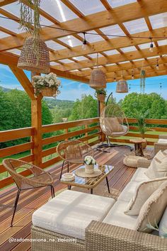 an outdoor living area with wicker furniture and wood planks, overlooking the valley