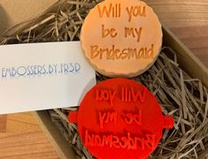 two cookies in a box with writing on them and a sign that says, will you be my bridesmad?