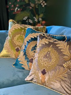 three decorative pillows on a blue couch