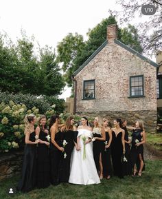 a group of women standing next to each other in front of a house