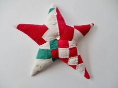 a red and green star ornament on a white surface