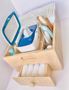 an open drawer with toothbrushes, soaps and other bathroom items in it