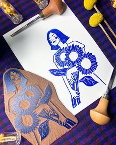 a blue and white paper with flowers on it next to some crafting supplies, scissors and other items