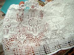 an old lace doily is laying on top of magazines