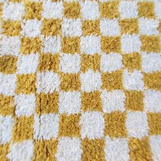 a yellow and white checkered blanket is laying on the floor