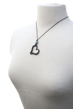 "Iron Heart Necklace, Hand Forged Iron, Blacksmith, Heart Necklace, Boho Necklace, Iron Jewelry, Iron Anniversary Gift This Blacksmith made heart necklace is finished off with an African turquoise bead and 2 silver beads. Hung from soft cotton cording and hooked with a lobster clasp. The length of the necklace cord is approximately 18\". The heart measures approximately 1.25 inches across. Each heart is handmade by me in a coal forge, shaped on the anvil, brushed, and finished with wax to preven Adjustable Heart Pendant Necklace With Heart Beads, Adjustable Heart Necklace With Heart Beads And Pendant, Adjustable Double Heart Necklace With Heart Beads, Black Open Heart Charm Necklace, Black Open Heart Necklace With Heart Charm, Coal Forge, Iron Anniversary Gifts, Iron Jewelry, Iron Heart