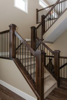 there is a staircase in the house with wood handrails and carpeted flooring