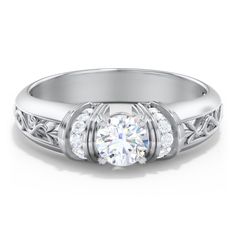 a white gold engagement ring with three stones on the side and an intricate design around the band