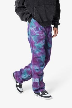 the Tie Dyed Cargo Pants are designed with a relaxed fit throughout with gusseting at the knee, cargo pockets at the front, a zipper fly, elastic and cargo drawcords at the leg openings, and finishing off with a tie dyed wash details relaxed fit* 100% cotton zipper fly drawcords at leg opening model is 6’1, 160 lbs and wears a size 30 78% cotton 22% poly Pink Casual Parachute Pants With Multiple Pockets, Pink Parachute Pants With Cargo Pockets For Streetwear, Pink Streetwear Bottoms With Cargo Pockets, Pink Parachute Pants With Pockets For Streetwear, Pink Streetwear Cargo Pants With Pockets, Pink Parachute Pants With Elastic Waistband For Streetwear, Pink Cargo Bottoms For Streetwear, Pink Cargo Pants For Streetwear With Pockets, Baggy Pink Cargo Pants With Cargo Pockets