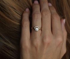 a woman's hand with a diamond ring on it