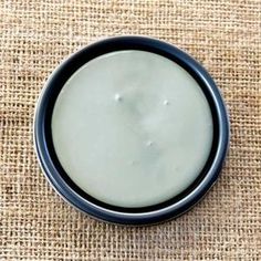 a black and white bowl sitting on top of a burlied cloth covered table