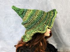 "This custom color forest witch hat is firmly shaped but soft enough to fold for travel. The brim is naturally wavy, but you can still play with where you want the waves to be exaggerated. The tip is sewn with a tuck to keep the point crooked, and the double thick yarn makes this hat firm enough to hang from a peg or sit on your dresser. You can add your own seasonal touch with pins, buttons, beads, flowers, etc through the crocheted stitching. This hat will take you through Fall, Winter, and Sp Green Bohemian Brimmed Sun Hat, Green Bohemian Hat, Adjustable Green Halloween Costume Hat, Adjustable Green Costume Hat For Halloween, Adjustable Green Costume Hats And Headpieces For Halloween, Green Sun Hat For Festival, Bohemian Green Hat With Short Brim, Bohemian Green Hats With Short Brim, Bohemian Green Sun Hat With Short Brim