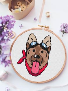 a cross - stitch picture of a dog with its tongue hanging out