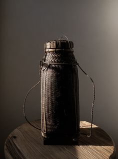 a black basket sitting on top of a wooden table