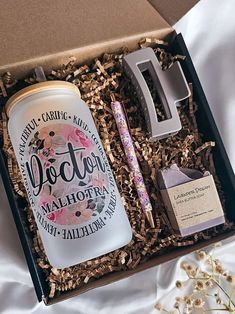 an open gift box containing a personalized flask, pen and notepad with the word victoria written on it