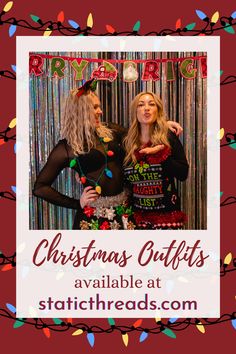 two women standing next to each other in front of a photo booth with christmas lights