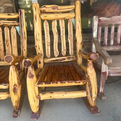 two wooden rocking chairs sitting next to each other on top of a cement floor in front of a store window