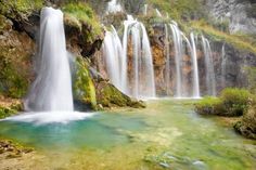 there is a large waterfall that has blue water in it