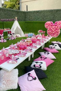 a table set up for a minnie mouse party with pink and black decorations on it