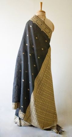 A genuine handloom product from the looms of Assam, India. The Sari has mulberry silk in the warp and eri silk in the weft and the interweaving motifs Muga Spun Silk and natural colour Eri Silk yarns. The mulberry silk in this case is raw mulberry silk . Known locally as 'kesa pat ' or 'nooni' . It has slight crispness and less sheen than the finer mulberry silk yarns.  Muga Spun is derived from the waste of muga silk cocoons and yarns. It doesn't have the bright golden sheen of the filament mug Black Tussar Silk Dupatta With Woven Motifs, Bohemian Chanderi Dupatta With Weaving Work, Gold Slub Silk Dupatta With Weaving Work, Gold Chanderi Dupatta With Woven Motifs, Gold Silk Dupatta With Woven Motifs, Black Handloom Slub Silk Dupatta, Handloom Tussar Silk Shawl, Traditional Handloom Silk Shawl, Handloom Raw Silk Pashmina Shawl For Festivals