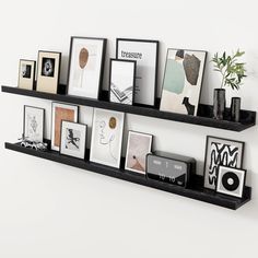 some black shelves with pictures and frames on them