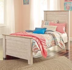 a white bed sitting in a bedroom on top of a hard wood floor next to a window