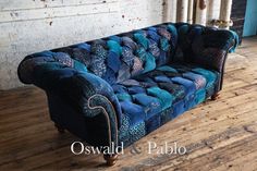 a blue couch sitting on top of a wooden floor